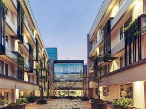 a courtyard of a building with potted trees in it at Mercure Jakarta Sabang in Jakarta