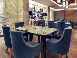 a dining room with tables and chairs with wine glasses at Mercure Jakarta Sabang in Jakarta