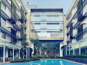 an apartment building with a swimming pool in front of it at Mercure Jakarta Sabang in Jakarta