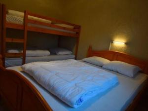 een groot wit bed in een slaapkamer met 2 stapelbedden bij Stylish Holiday Home in Xhoffraix with Terrace in Xhoffraix