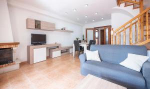 a living room with a blue couch and a television at Casa adosada 50m de la playa Calafell . WIFI gratis in Calafell
