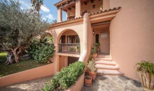 卡拉费尔Villa tennis park with air conditionner的带阳台和盆栽植物的房子