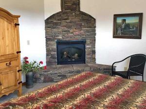 a living room with a stone fireplace with a bed at Slot Canyons Inn Bed & Breakfast in Escalante