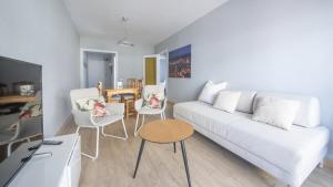 uma sala de estar com um sofá branco e cadeiras em R68 Apartamento Montserrat 32-3 em Calafell