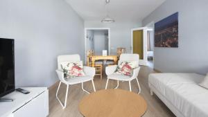 uma sala de estar com um sofá e duas cadeiras e uma mesa em R68 Apartamento Montserrat 32-3 em Calafell