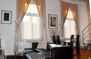 a living room with a couch and two windows at Welcome Budapest Apartments in Budapest