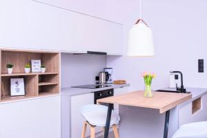 a white kitchen with a table and a chair at Comfy Apartments - Old Town Center in Gdańsk