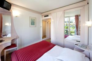 a hotel room with a bed and a mirror at Hotel Zorna Plava Laguna in Poreč