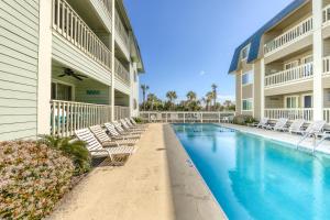 a swimming pool at a resort with chairs and a building at Oceanside 212-C in Isle of Palms