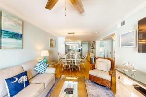 uma sala de estar com um sofá e uma mesa em Oceanside 212-C em Isle of Palms