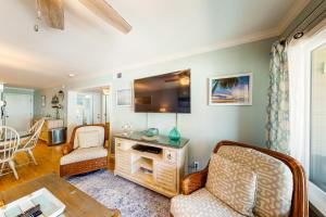 a living room with two chairs and a tv at Oceanside 212-C in Isle of Palms