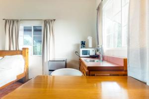 a bedroom with a bed and a desk with a microwave at Isebei Guest House in Hopkins