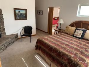 ein Schlafzimmer mit einem Bett, einem Stuhl und einem Kamin in der Unterkunft Slot Canyons Inn Bed & Breakfast in Escalante
