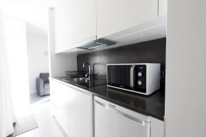 uma cozinha com um micro-ondas no balcão em I Loft Porto no Porto