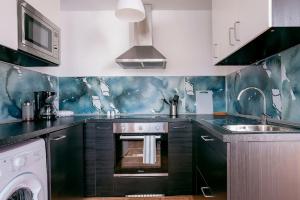 Una cocina con estufa y fregadero. en Arrecife, en Arrecife