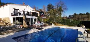 a house with a swimming pool in front of a house at VILLAS COSETTE - Villa Martina in Caldes de Malavella