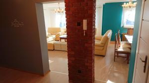a room with a brick wall and a living room at BASTÓWKA 2 Apartamenty in Ustroń