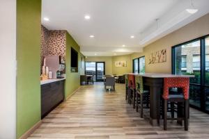 a kitchen with green walls and a bar with stools at La Quinta by Wyndham Pomona in Pomona