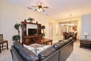 a living room with a leather couch and a television at 7741 Windsor Hills in Orlando