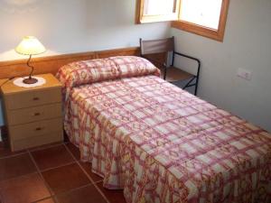 a bedroom with a bed and a table and a lamp at Tossal del Maig in Barbará