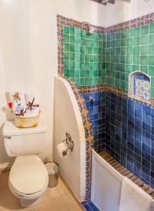 y baño con aseo y ducha con azulejos azules. en Hotel & Spa La Mansion del B Azul, en Querétaro