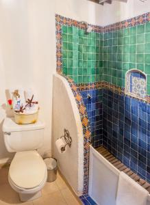 uma casa de banho com um WC e um chuveiro com azulejos azuis em Hotel & Spa La Mansion del B Azul em Querétaro