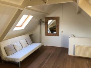 - un salon avec un canapé blanc et un miroir dans l'établissement Green Garden House, à Amersfoort