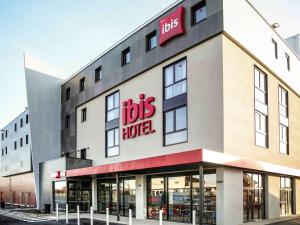 un grand bâtiment avec un panneau d'hôtel pour le bus dans l'établissement Ibis Niort Est Mendes France, à Niort