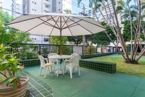 - une table et des chaises avec un parasol sur la terrasse dans l'établissement Excelente 3 Quartos Rua Navegantes em Boa Viagem No melhor local da praia SAL802, à Récife