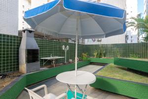 - une table et des chaises avec un parasol bleu sur la terrasse dans l'établissement Excelente 3 Quartos Rua Navegantes em Boa Viagem No melhor local da praia SAL802, à Récife