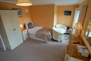 a bedroom with a bed and a chair and a desk at Murphys Farmhouse B&B in Castlemaine