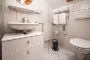 une salle de bain blanche avec un lavabo et des toilettes dans l'établissement Kolmsteiner Hof, à Neukirchen beim Heiligen Blut