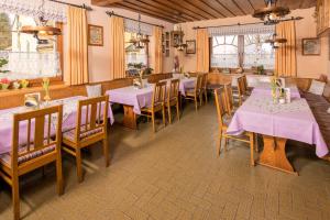 ノイキルヒェン・バイム・ハイリゲン・ブルートにあるKolmsteiner Hofのピンクのテーブルクロスが敷かれたテーブルと椅子が備わるレストラン