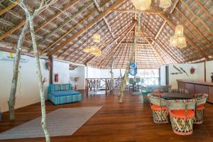 een grote woonkamer met een houten plafond en stoelen bij Ecovergel Hotel Riviera Maya in Chemuyil