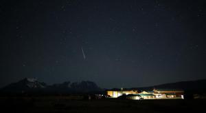 Una noche estrellada con un edificio y una montaña en Río Serrano Hotel + Spa, en Torres del Paine