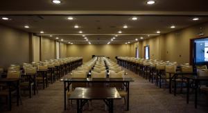 a large room with tables and chairs and a screen at Río Serrano Hotel + Spa in Torres del Paine +37 photos