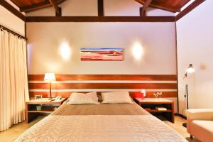 - une chambre avec un lit, deux tables et un canapé dans l'établissement Bupitanga Hotel, à Pipa