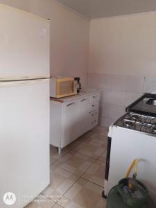 uma cozinha com um frigorífico branco e um micro-ondas em Edícula. Ent.independente em Sorocaba