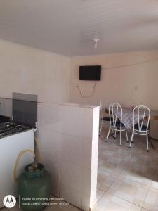uma cozinha com duas cadeiras e uma televisão na parede em Edícula. Ent.independente em Sorocaba