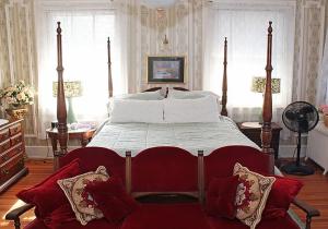 um quarto com uma cama grande e almofadas vermelhas e brancas em Port City Guest House em Wilmington