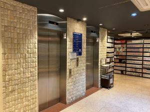 un vestíbulo con dos ascensores en una tienda en 3s HOTEL HIRATSUKA, en Hiratsuka