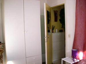 1 dormitorio con armario blanco y puerta en Toit pour Vous Chambre d'hôtes, en París
