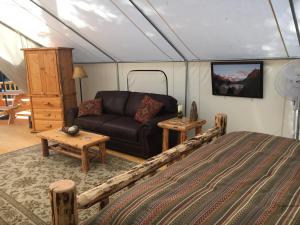 a bedroom with a bed and a couch in a tent at North Forty Resort in Columbia Falls