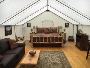 a living room with a large bed in a tent at North Forty Resort in Columbia Falls