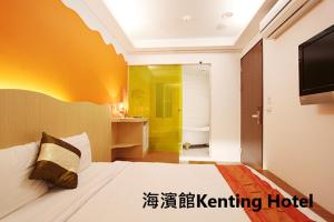 a bedroom with a large bed with a tv and a room at Kenting Hostel in Kenting