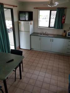 a kitchen with a refrigerator, sink, and dishwasher at Coral Coast Tourist Park in Townsville