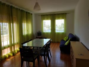 a living room with a table and a couch at PORT LA SARDANA EmpuriaRent in Empuriabrava