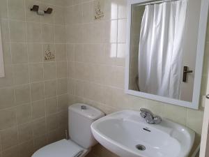 a bathroom with a toilet and a sink and a mirror at PORT LA SARDANA EmpuriaRent in Empuriabrava +53 photos