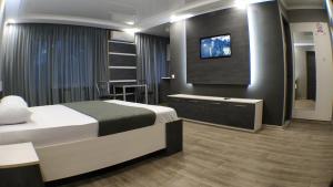 a hotel room with a bed and a flat screen tv at Двухкомнатный люкс центр Металлургов 19 KR Apartments in Kryvyi Rih