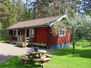 una piccola cabina rossa con un tavolo da picnic di fronte ad essa di Sifferbo Stugby a Sifferbo